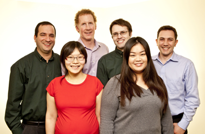 Four men and two women pose together for a portrait.